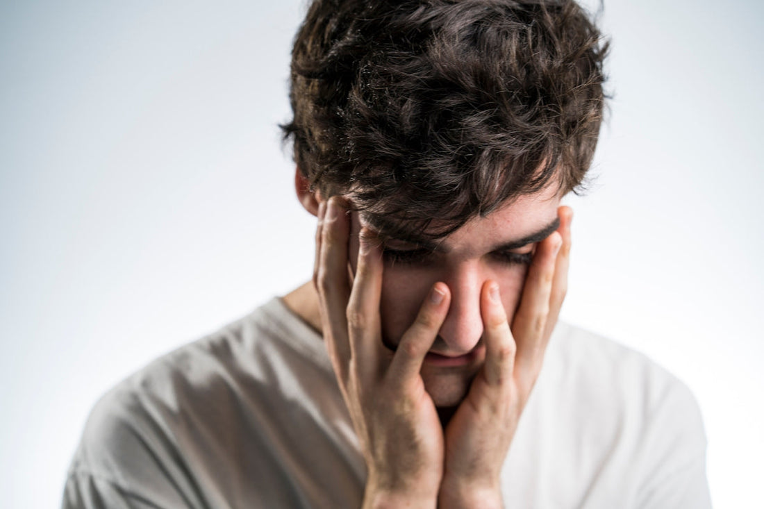 man touching face with both hands
